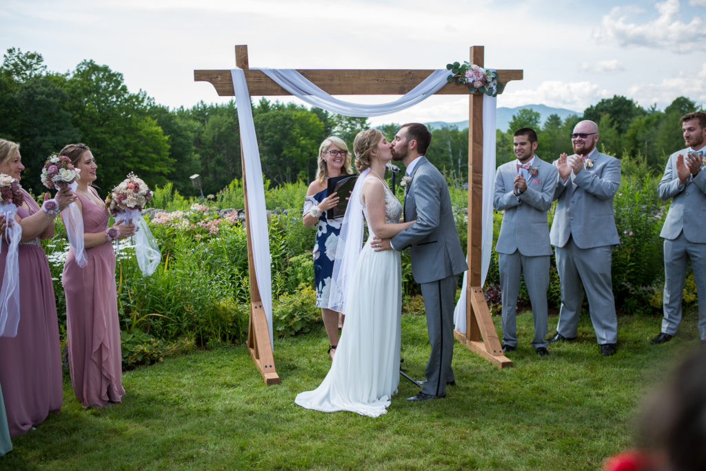 first kiss as husband and wife at NH summer barn wedding 