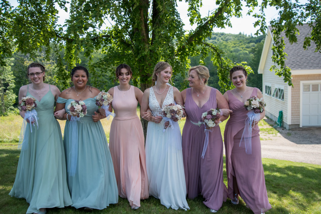 bride and bridesmaids walking and smiling at each other