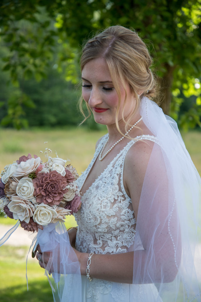 up close of bride looking at her flowers at NH Summer barn wedding