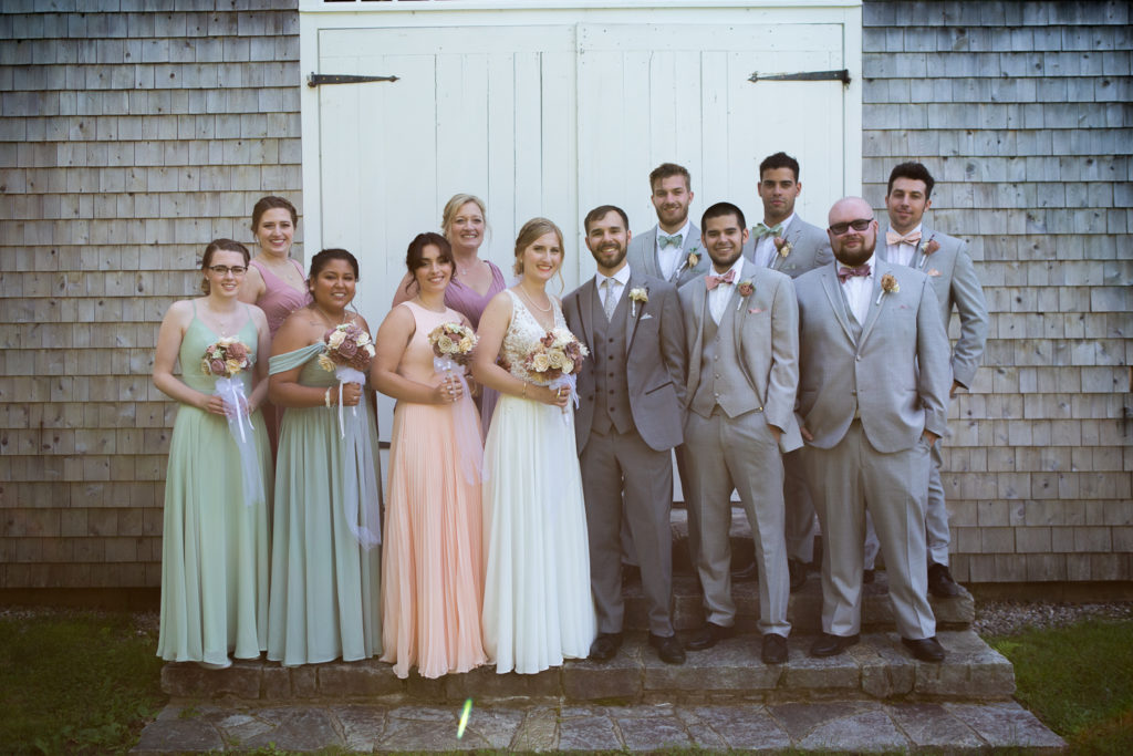 whole bridal party posing in front of the barn at NH summer barn wedding at Barn at Moody Mountain Farm