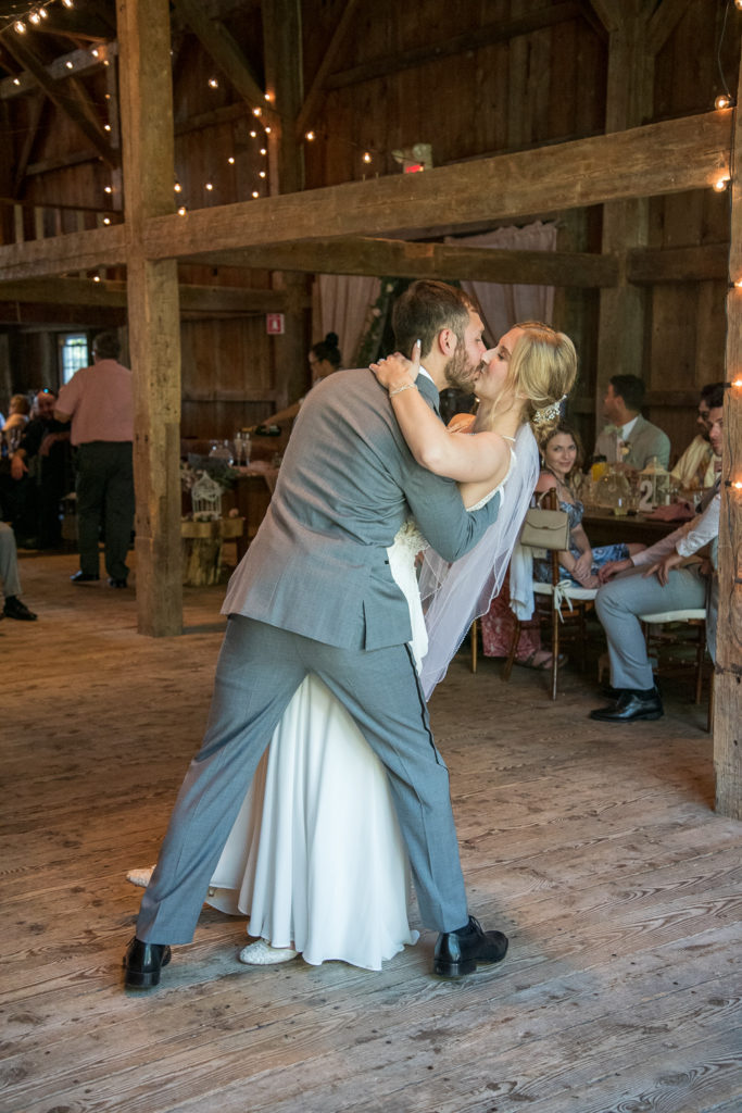groom dipping his bride during first dance at NH summer barn wedding