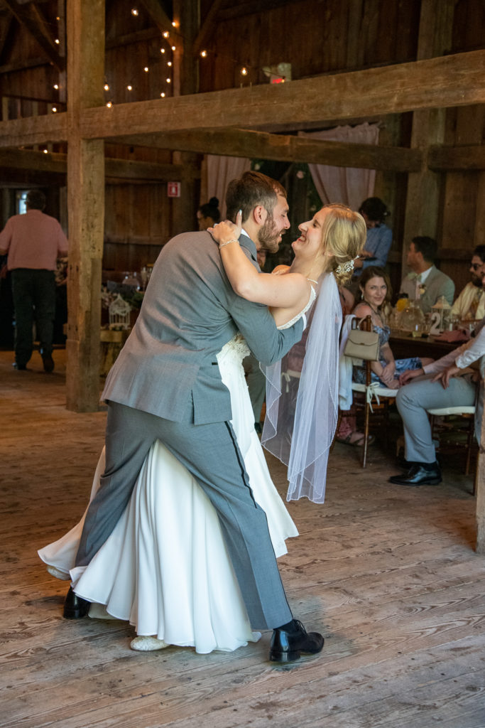 groom dipping his bride during first dance at NH summer barn wedding at Barn at Moody Mountain Farm 