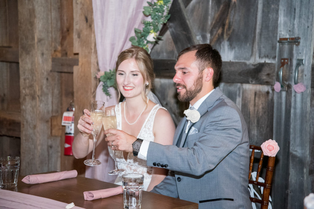 bride and groom clinking their glasses together to cheers