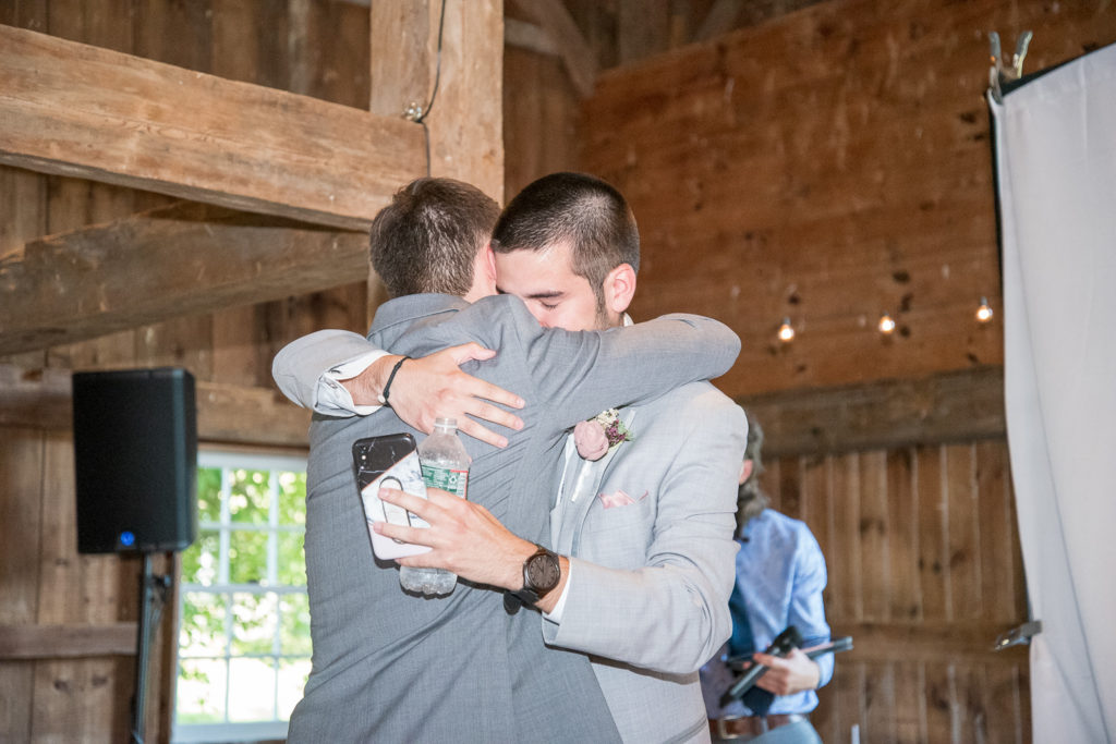 groom hugging his brother, the best man after his speech