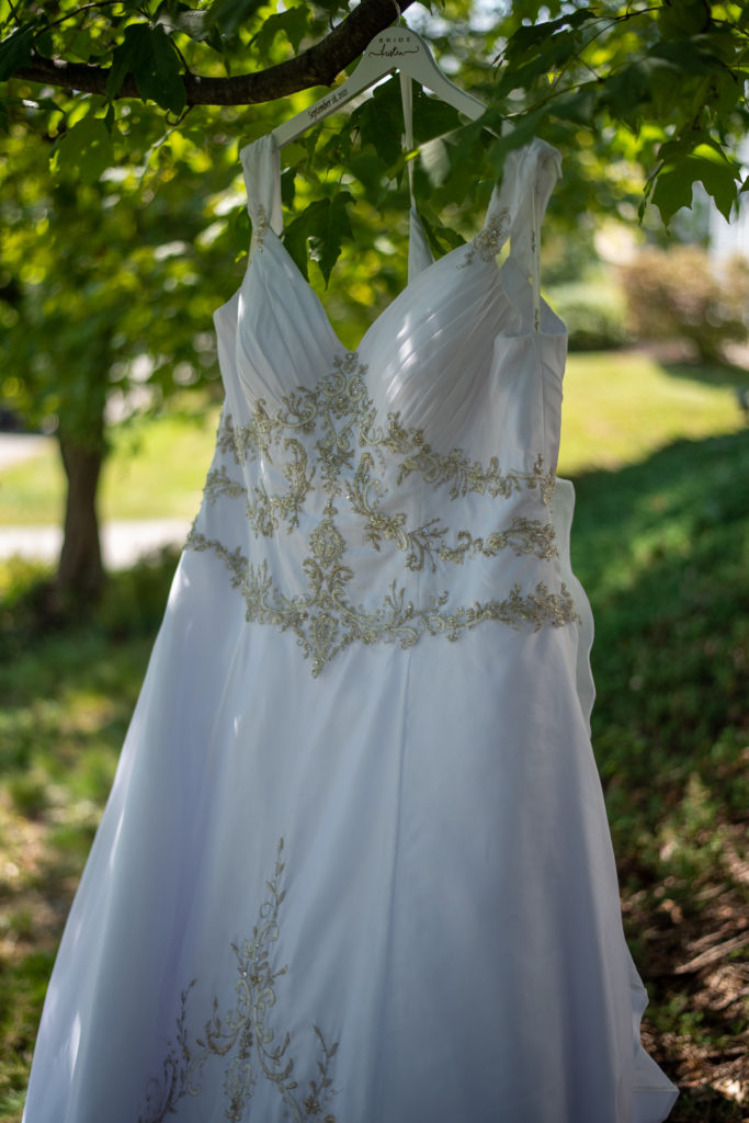 bride's dress hanging from a tree at The Oaks Somersworth NH wedding