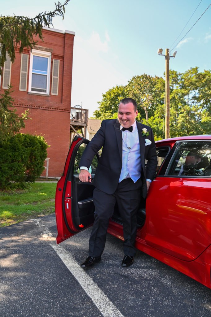 groom arriving to church in his red sports car