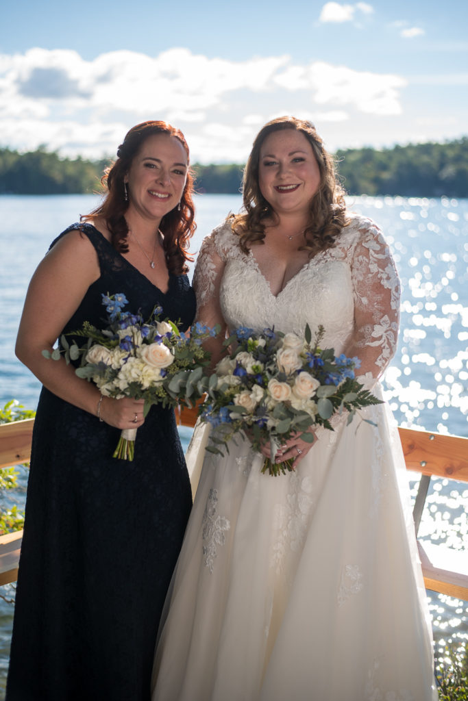 bride with her girls with lake in the background at wedding at the lake