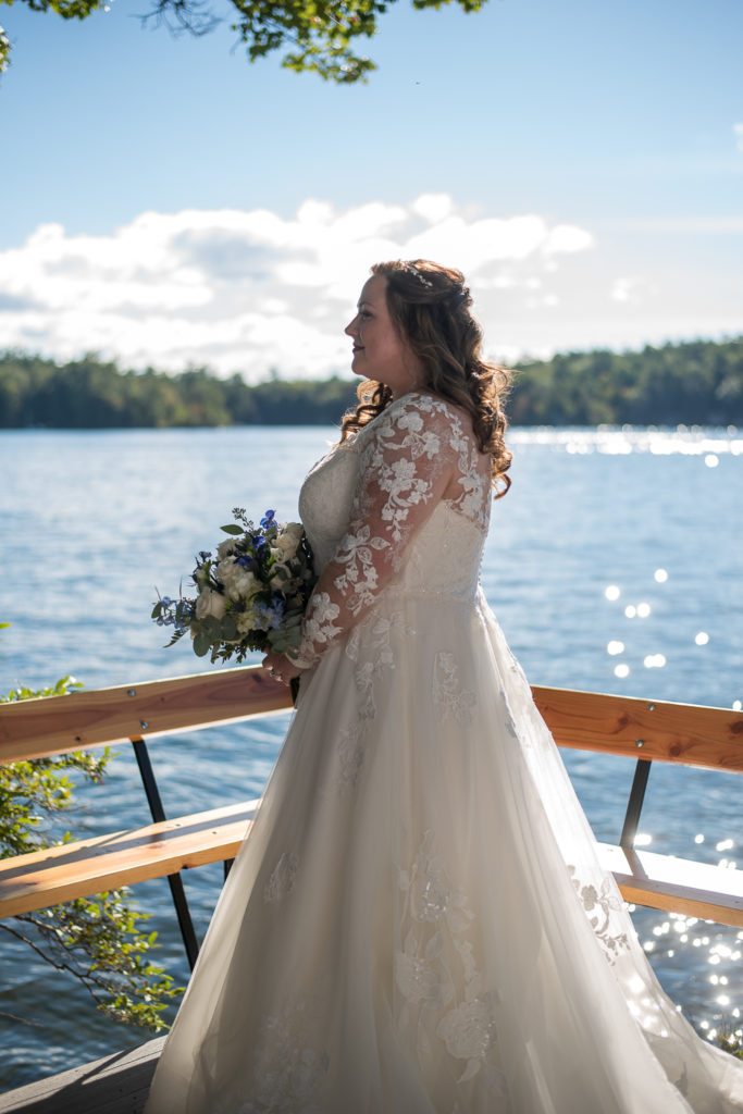 bride standing with lake in the background at wedding at the lake