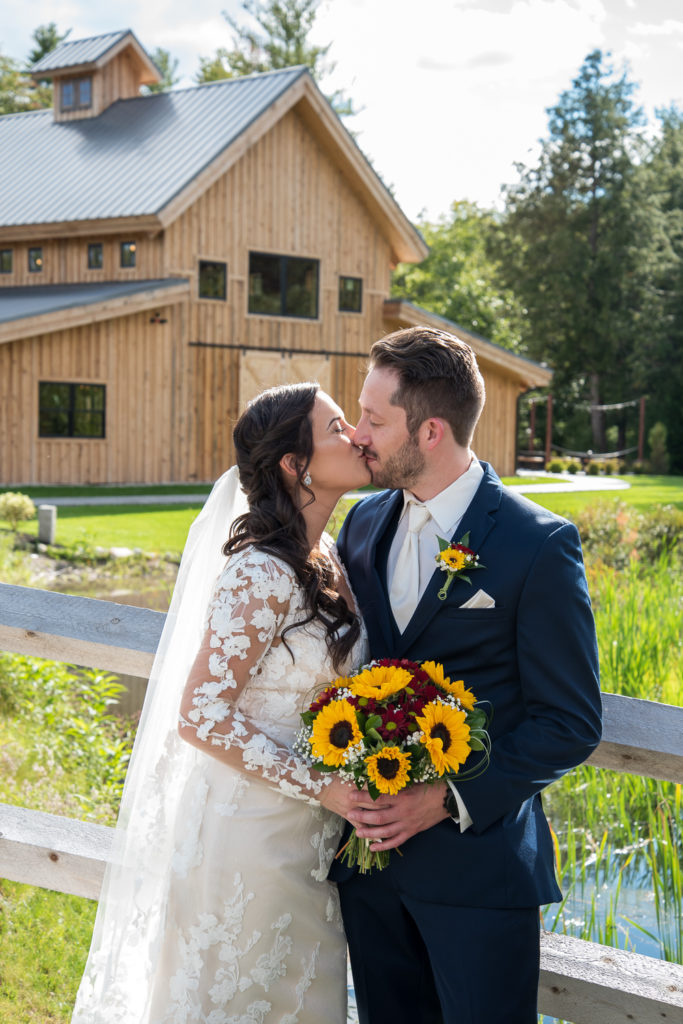 bride and groom posing in front of the barn at bull meadow