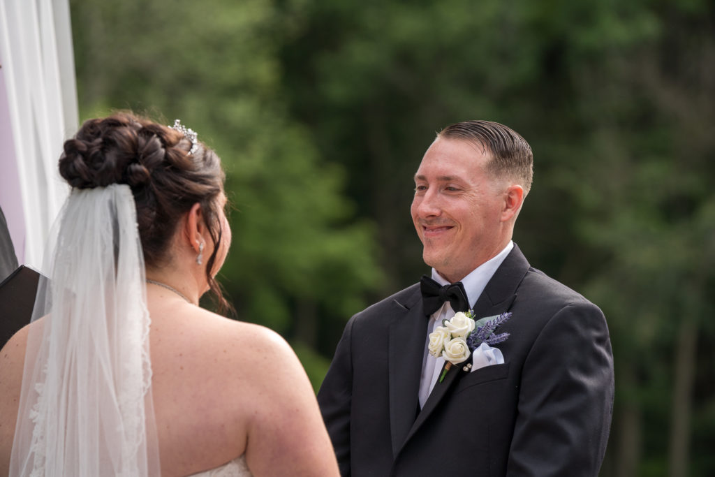 Derek & Tiffany (bride and groom) wedding - Derek smiling at Tiffany during the ceremony