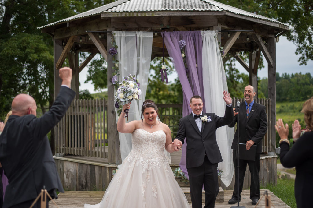 Derek & Tiffany (bride and groom) wedding - Tiffany and Derek cheering as they walk down the aisle