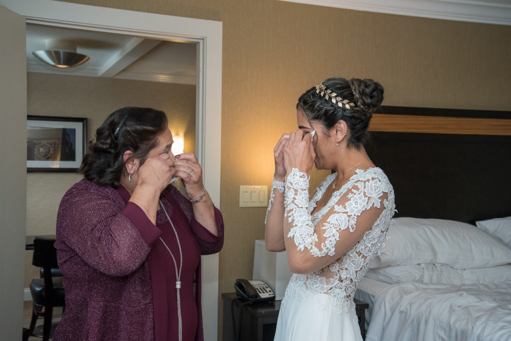 mother of bride and bride wiping their tears away