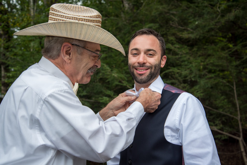father of the groom tying the groom's tie, shot by NH wedding Photographer