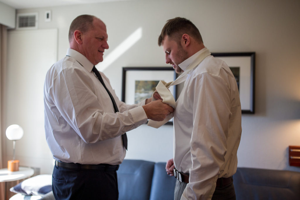 father of the groom tying the groom's tie, shot by NH wedding Photographer