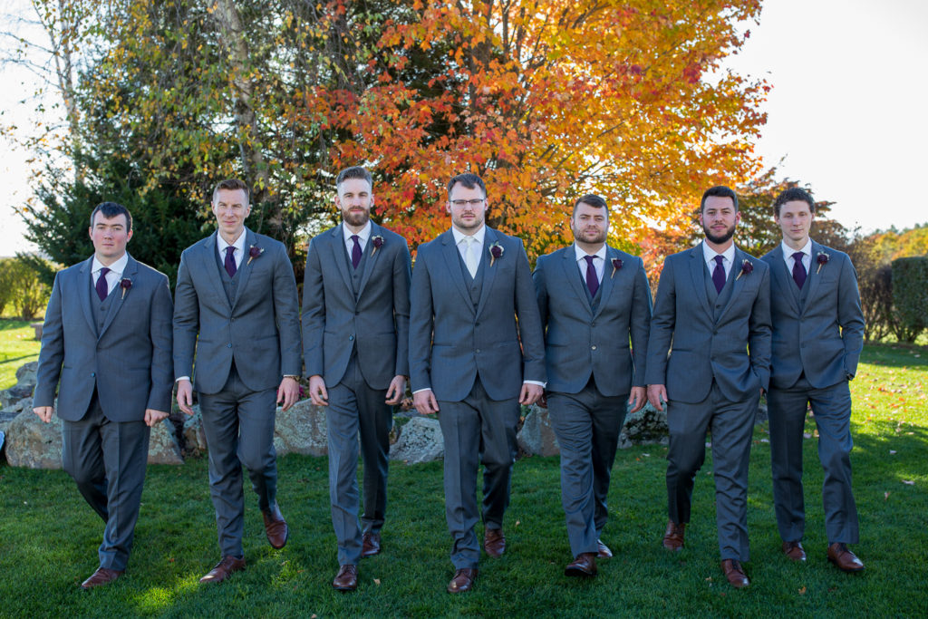 groom with his groomsmen in front of a pretty orange tree at the perfect fall wedding