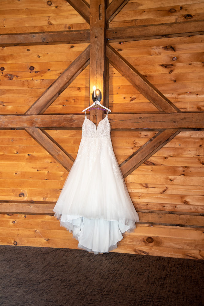 wedding dress hanging up on a barn wall at the perfect fall wedding