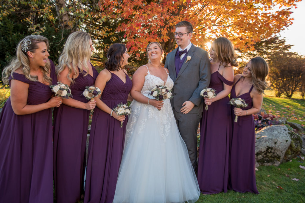 bride with her bridal party in front of the foliage tree at the perfect fall wedding