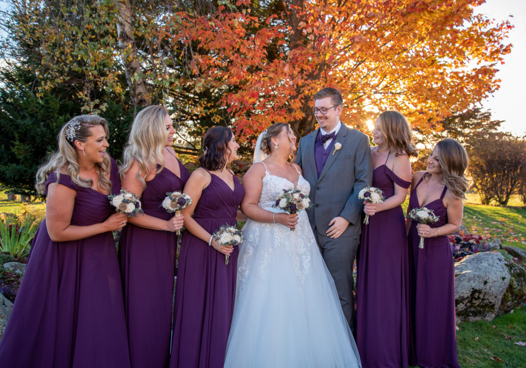bride with her bridal party in front of the foliage tree at the perfect fall wedding