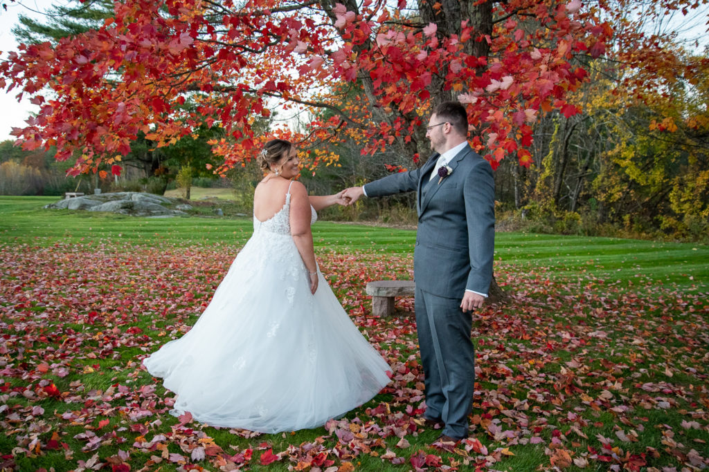 bride and groom dancing in front of a red foliage tree at the perfect fall wedding 
