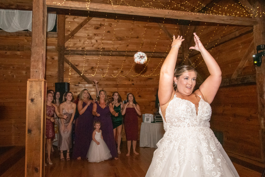 bride throwing a white pumpkin to  all the single ladies at the perfect fall wedding 