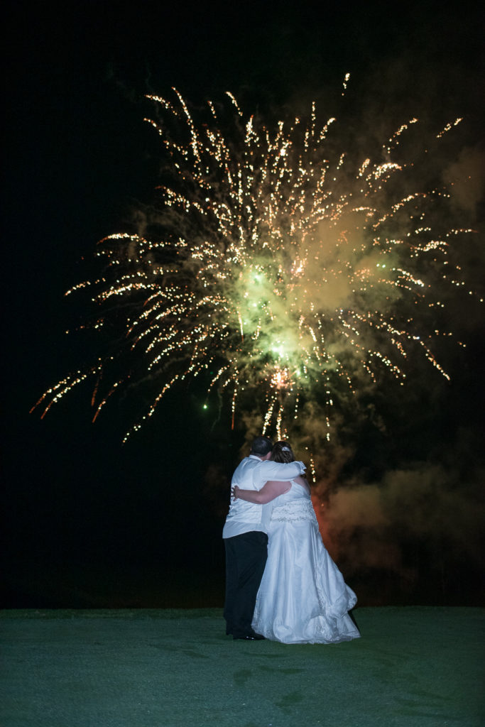bride and groom hugging watching fireworks