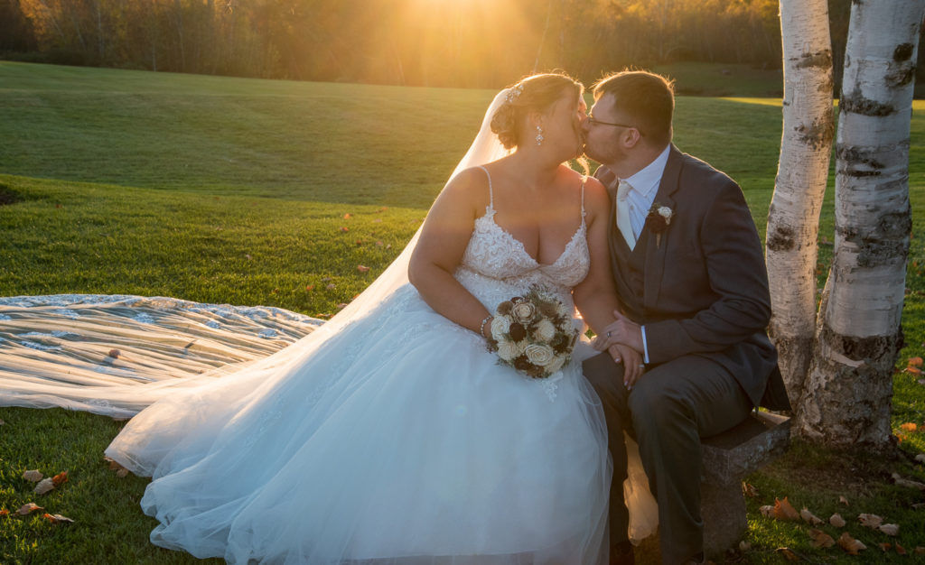 bride and groom kissing with the sun setting behind them. 2021 wedding