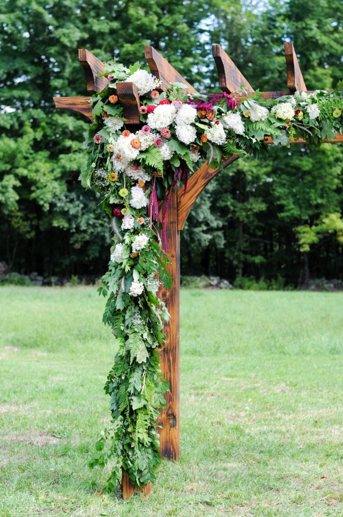 Beautiful wedding arbor with garland made by groom's cousin