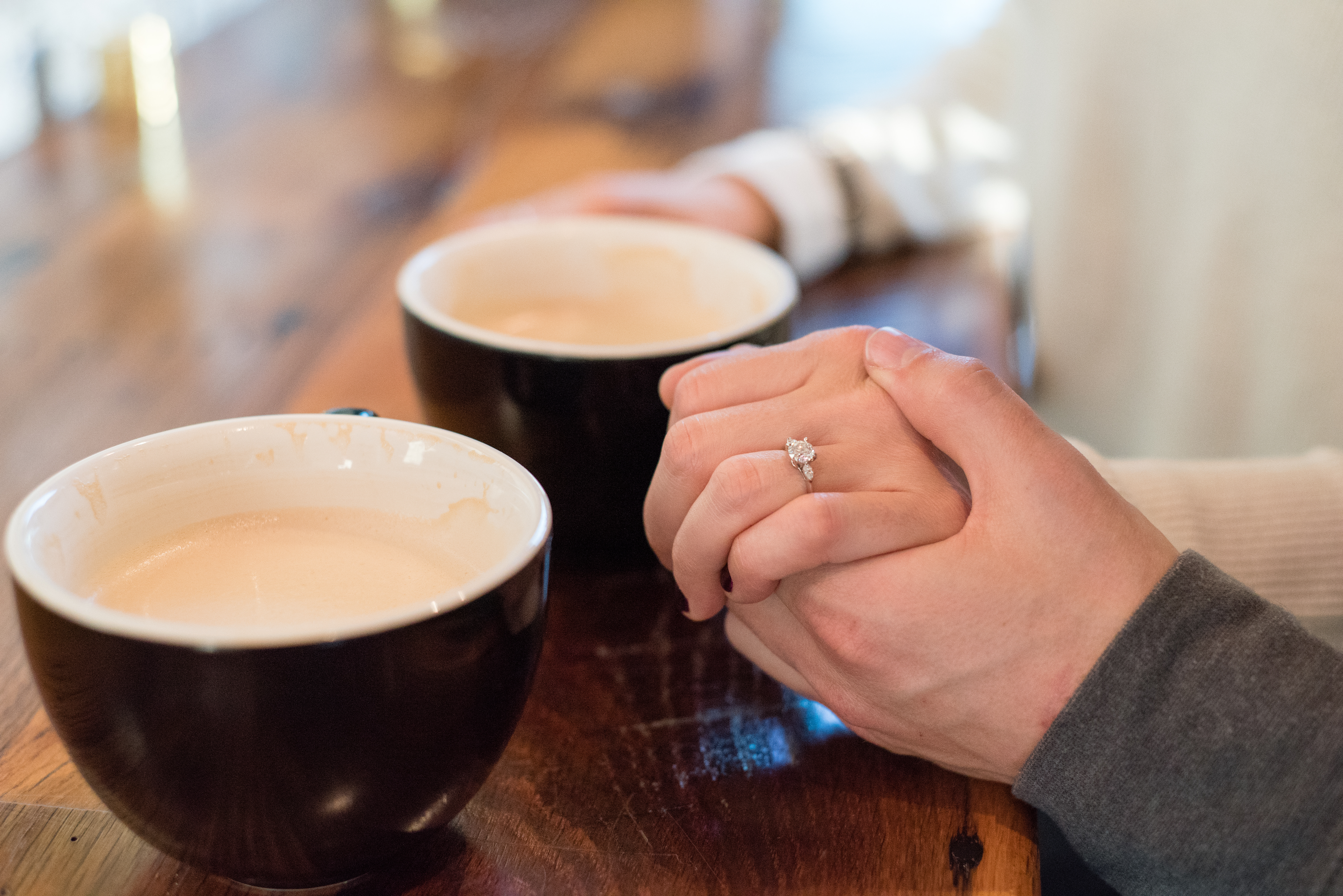 close up of coffee mugs and engagement ring