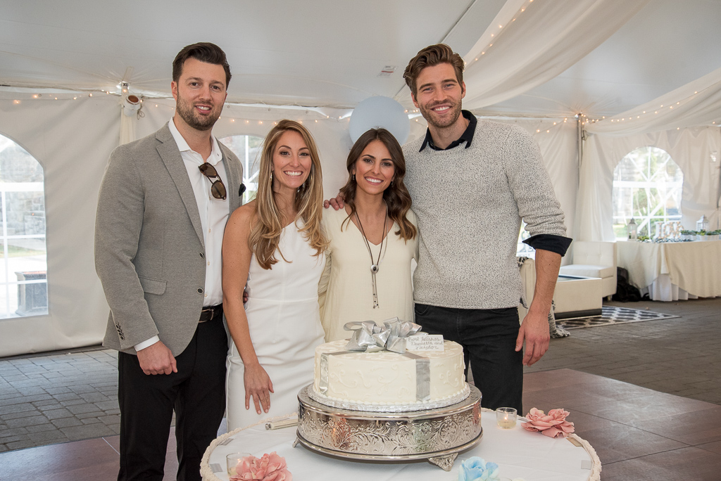 brides and grooms posing with their bridal shower cake