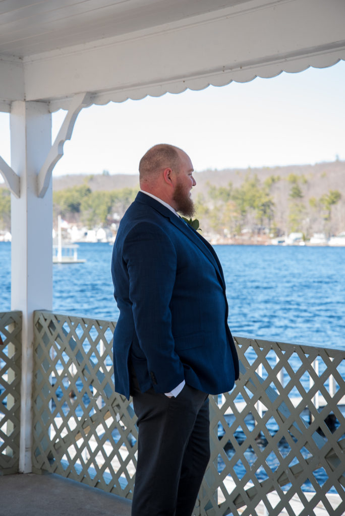 groom looking out over the water waiting for his bride