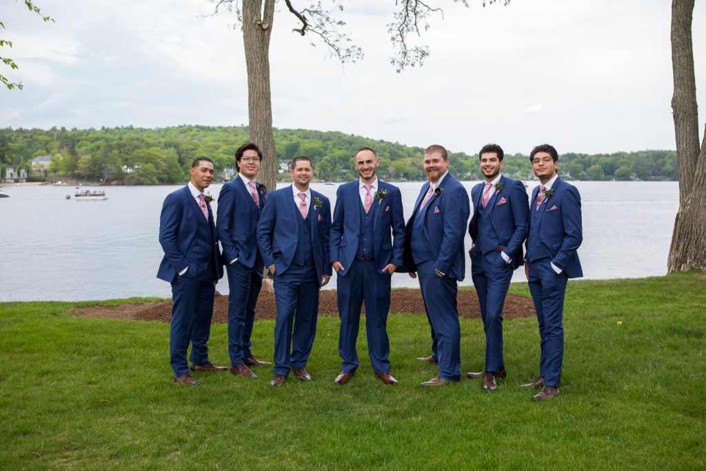 groom with his guys standing in front of the lake