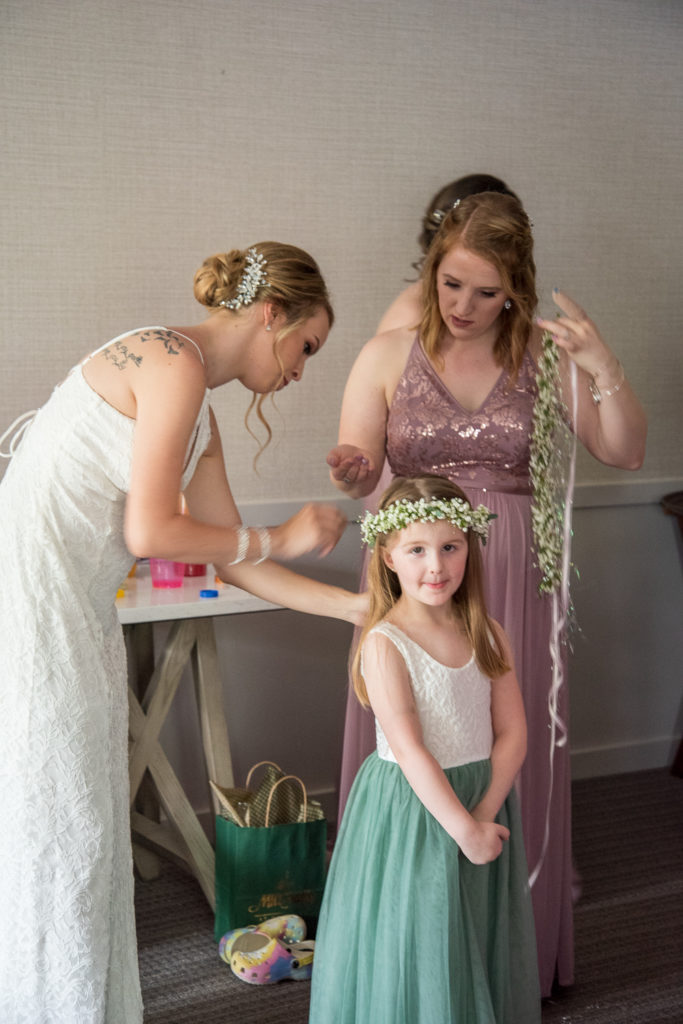bride putting on flower crowns on the flower girls