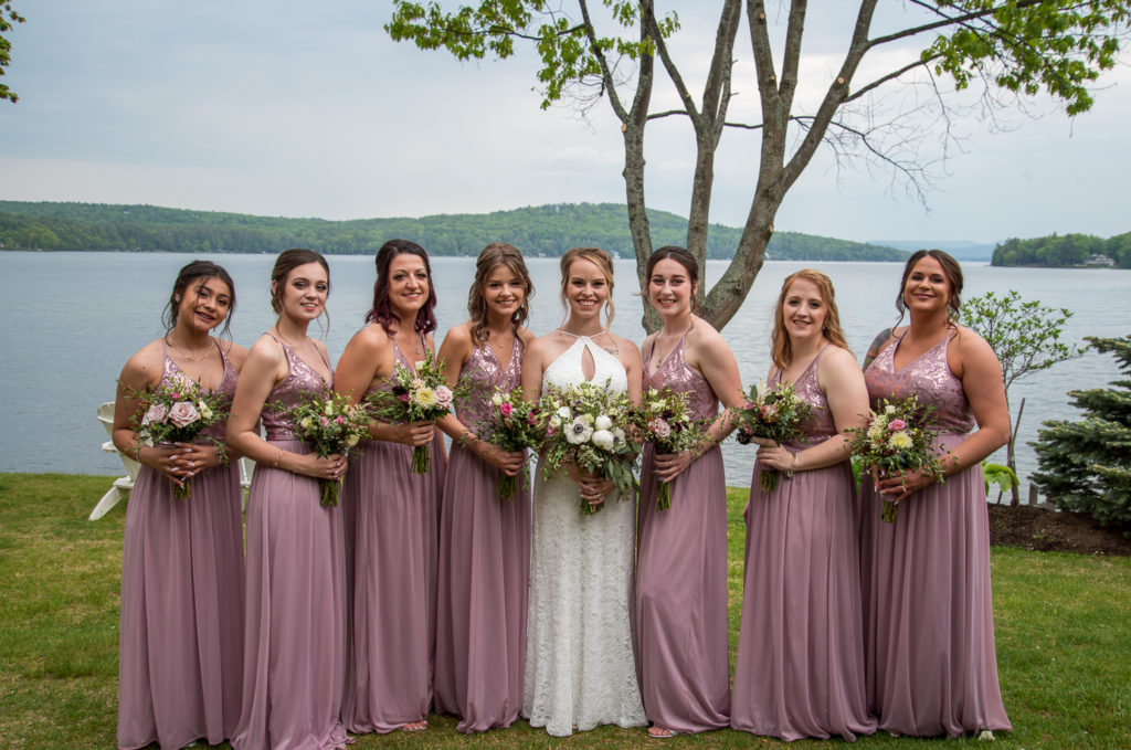 bridesmaids with the bride in front of the lake