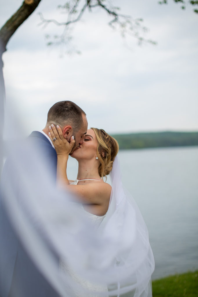 bride and groom kissing behind the veil 