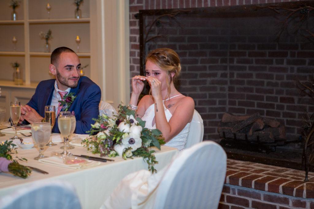 bride crying while listening to her sister's maid of honor speech at the wedding