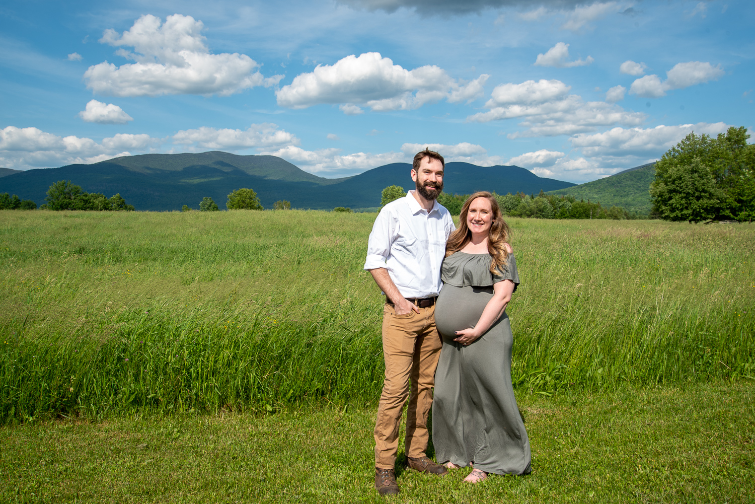 mom and dad to be in a field with the white mountains in the background
