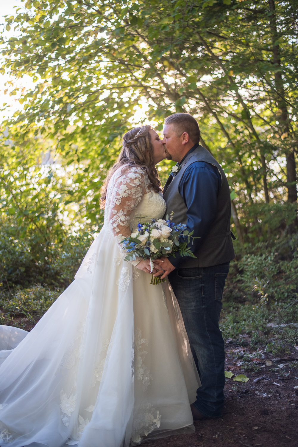 bride and groom kissing at wedding at the lake