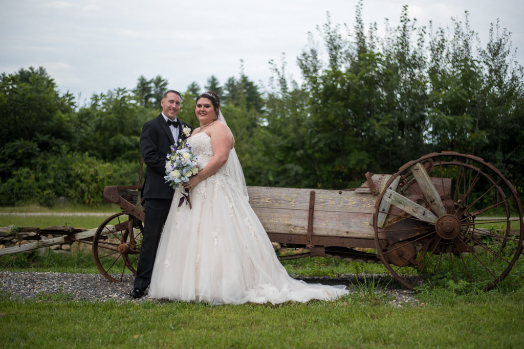 bride and groom in front of an old wagon