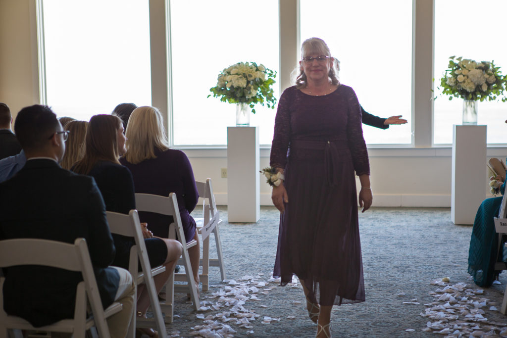 mother of bride walking down aisle leaving the ceremony at winter oceanside wedding