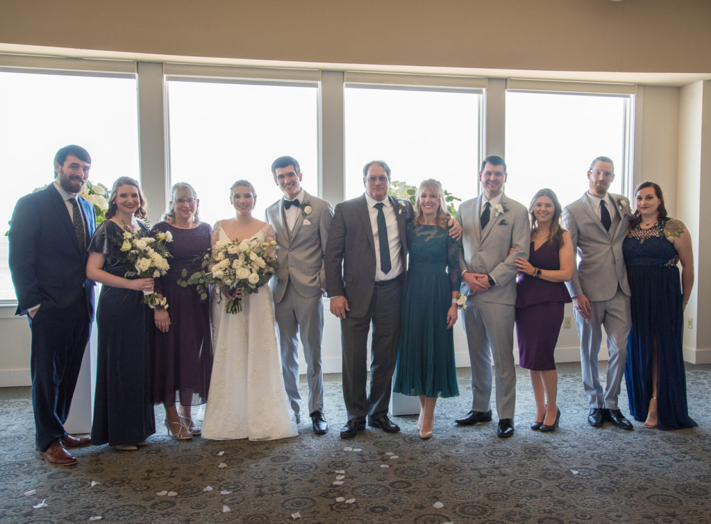 bride and groom's family all together after joining families at winter oceanside wedding 
