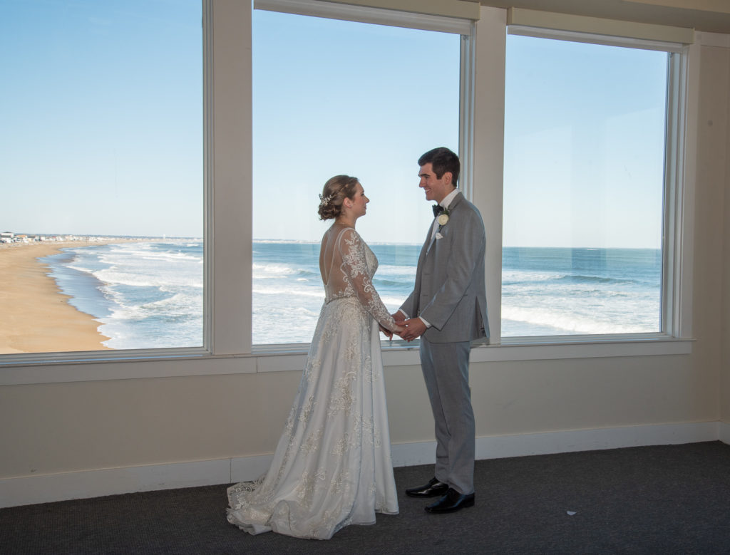 bride and groom looking at each other holding hands with ocean in the background at winter oceanside wedding
