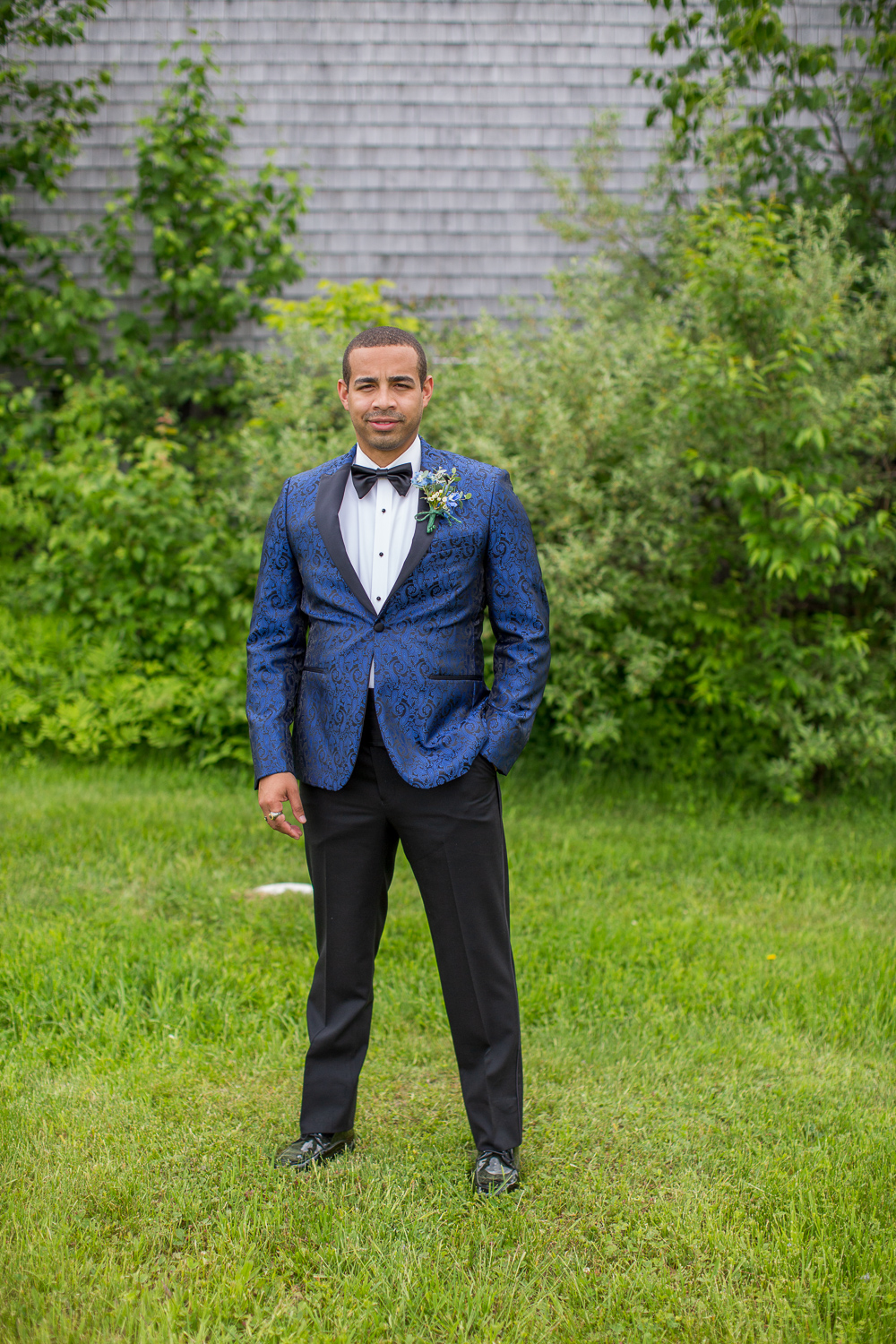 groom posing in front of the whitney farm estate barn on the perfect day