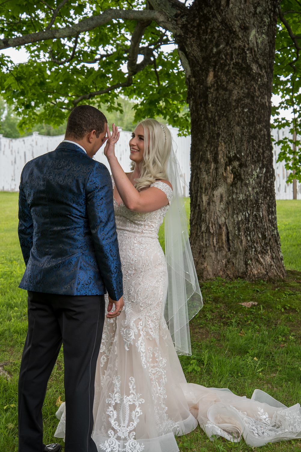 bride wiping a tear from groom's face on the perfect day