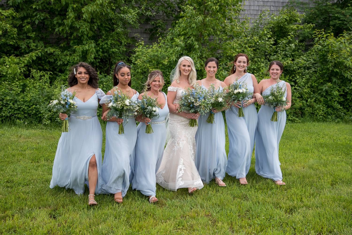 bride with her bridesmaids in front of the Whitney Farm Estate at the perfect day