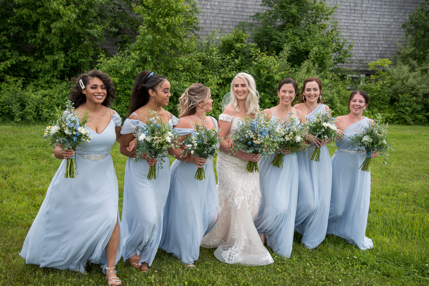 bride with her bridesmaids in front of the Whitney Farm Estate at the perfect day