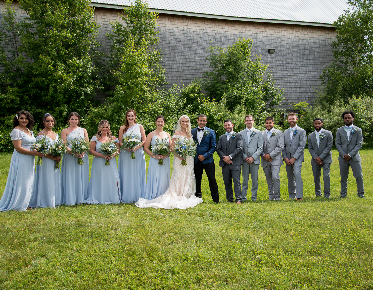 whole bridal party with the couple at the Whitney Farm Estate barn at the perfect day