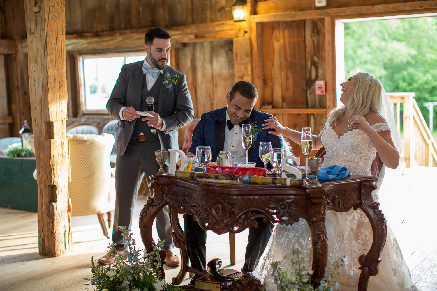 best man giving her speech to bride and groom at the sweetheart table at the perfect day