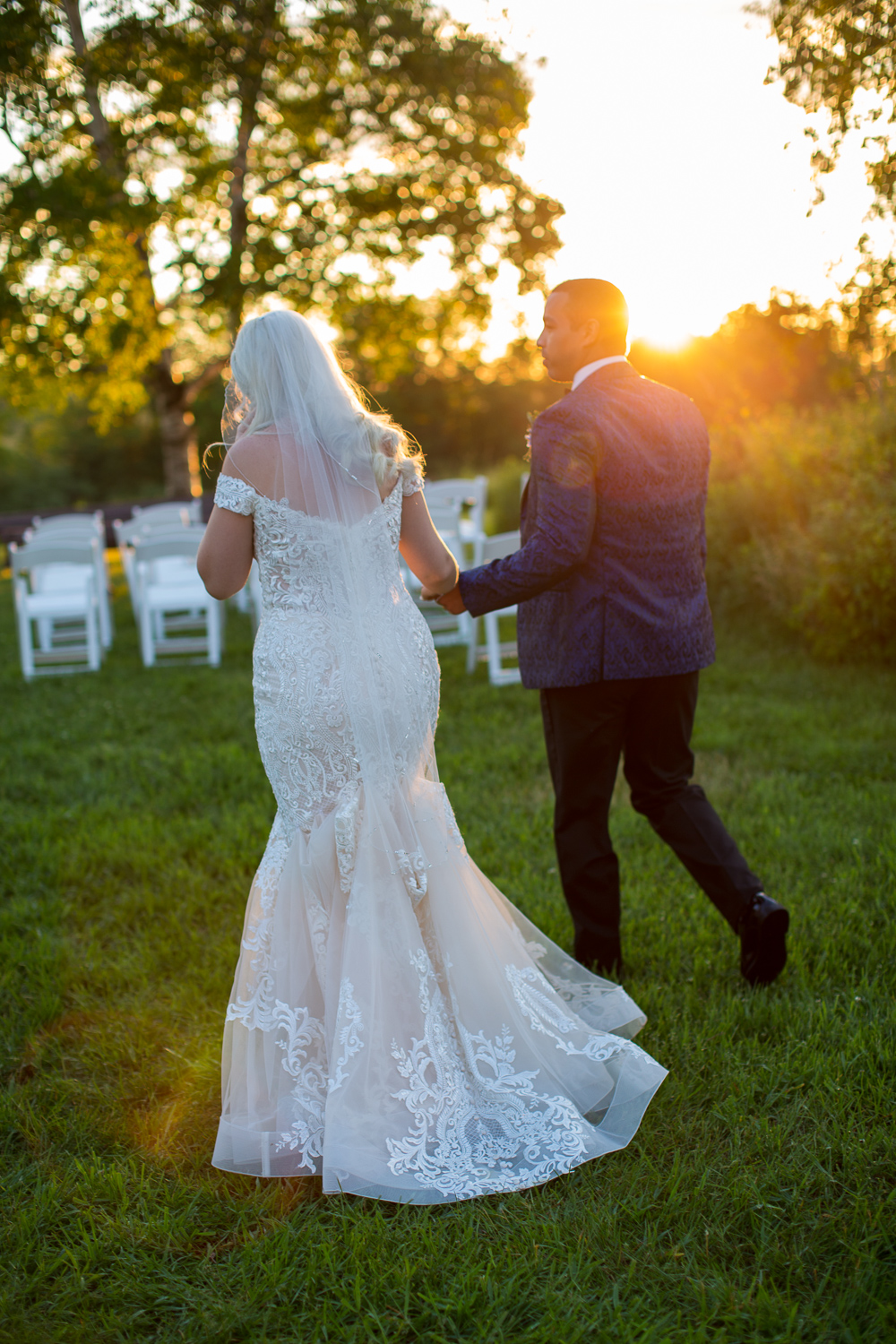 bride and groom during sunset photos walking holding hands at the perfect day