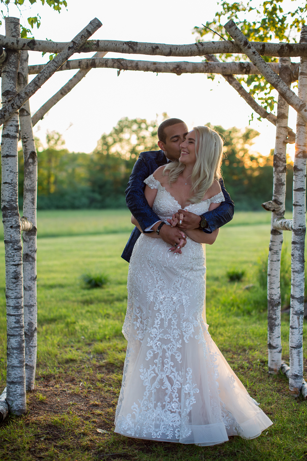 bride and groom posing with sun setting behind them at the perfect day at whitney farm estate in oxford maine