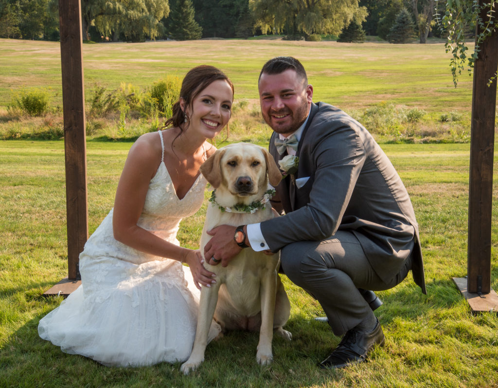 bride and groom with their flower "girl" puppy. a golden lab